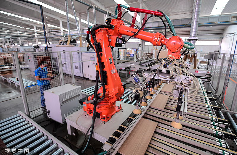 Robotické rameno pracuje na výrobní lince vytvářející kuchyňské vybavení v Shenyangu, provincii Liaoning v severovýchodní Číně, 8. června 2022.