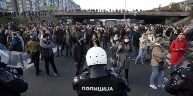 Policie v zásahové výstroji stojí s demonstranty blokujícími dálnici E-75 v Bělehradě, Srbsko, 27. listopadu 2021. Protivládní demonstranti zablokovali silnice a mosty v Srbsku na protest proti novým zákonům, které podle nich podporují zájmy zahraničních investorů devastujících životní prostředí.